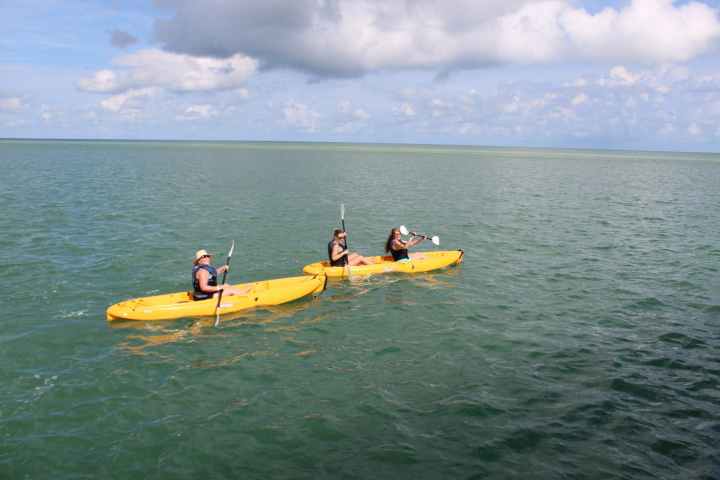 a group of people riding on the back of a boat in the water