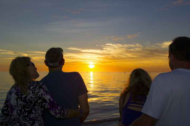 a group of people standing next to a body of water