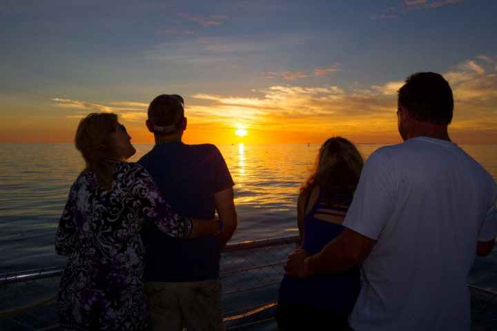 a group of people standing next to a body of water